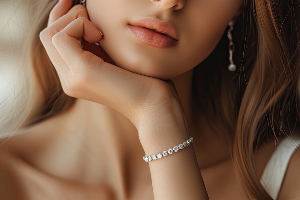 A woman wearing a pearl bracelet and earring.