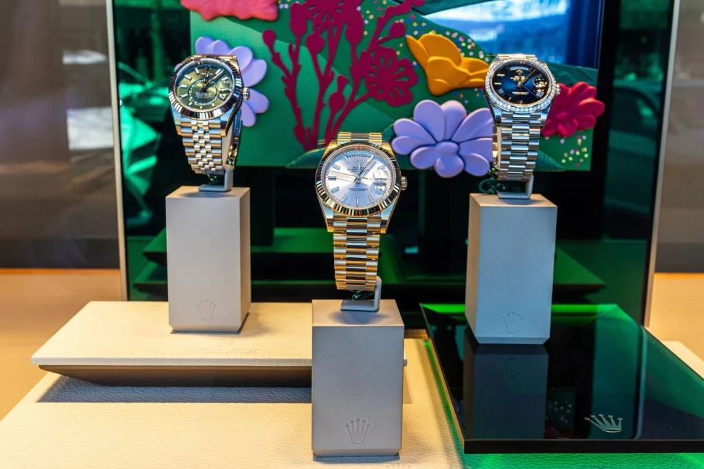 Rolex watches, including Rolex Oyster Perpetual Day-Date at center, three luxury watches displayed in a store window