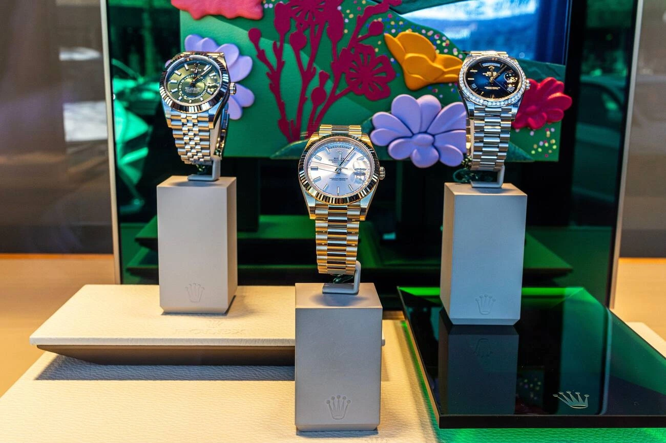 Rolex watches, including Rolex Oyster Perpetual Day-Date at center, three luxury watches displayed in a store window