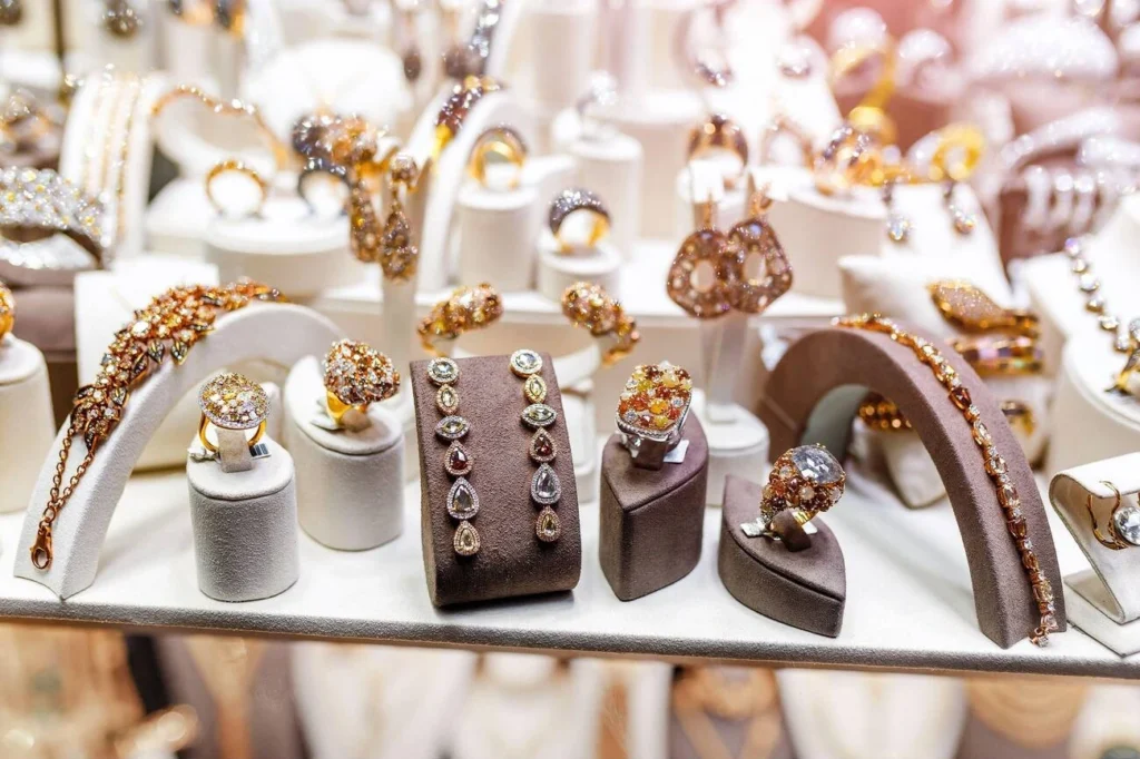 A collection of luxury gold and silver jewelry, including rings and necklaces, used to illustrate the key factors that determine jewelry market value.